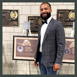 Chris standing next to his hall of fame plaque